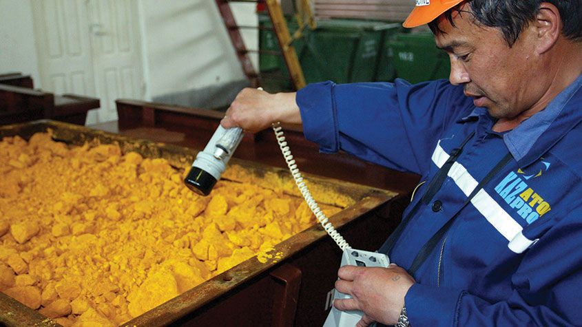 Worker checking radiation level of uranium oxide