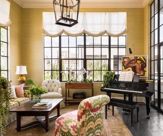 sun room with steel framed windows and piano with plants