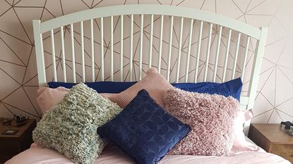 bedroom with pink geometric wallpaper and white bed