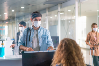 man checking into flight after finding out whether it is safe to book holiday in 2021