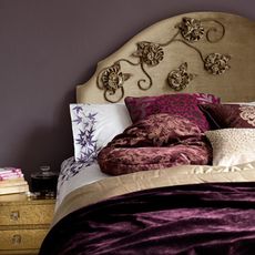 bedroom with eggplant coloured wall and pillows