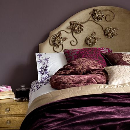 bedroom with eggplant coloured wall and pillows