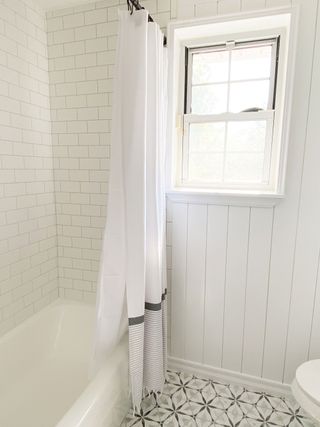 Bathroom with patterned floor tiles and white shower curtain