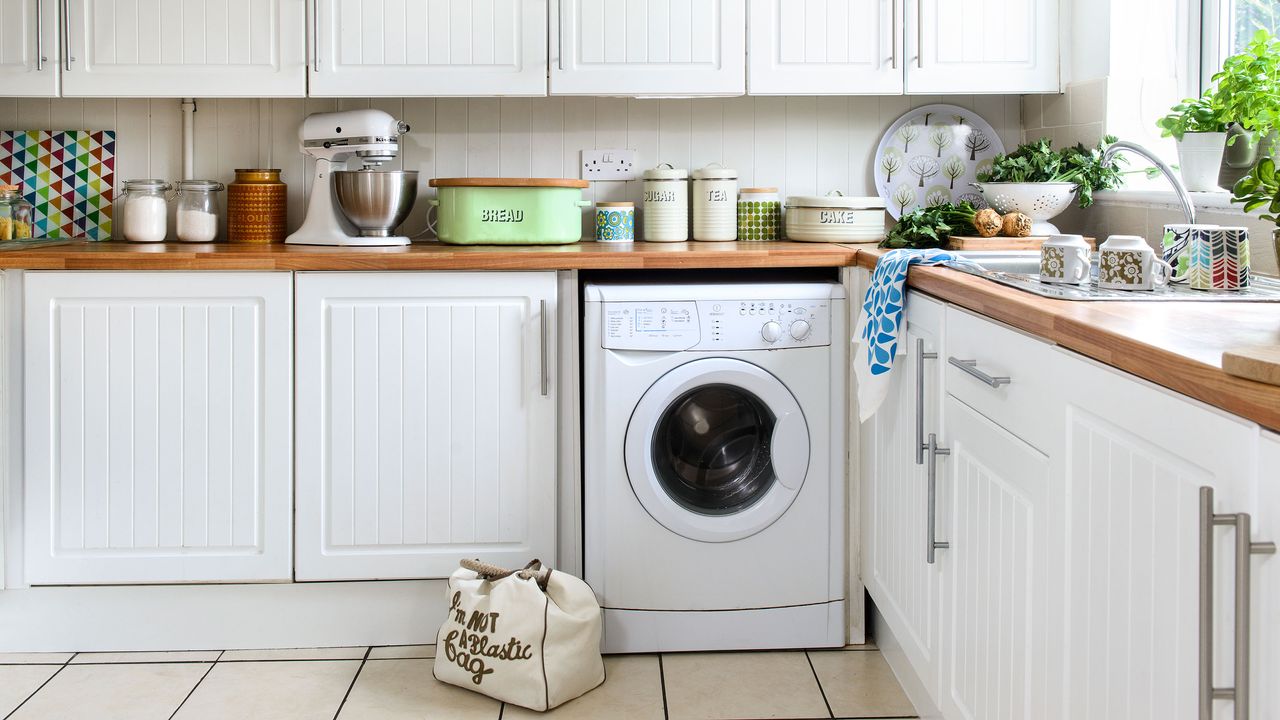 white kitchen with washing machine built into cabinetry