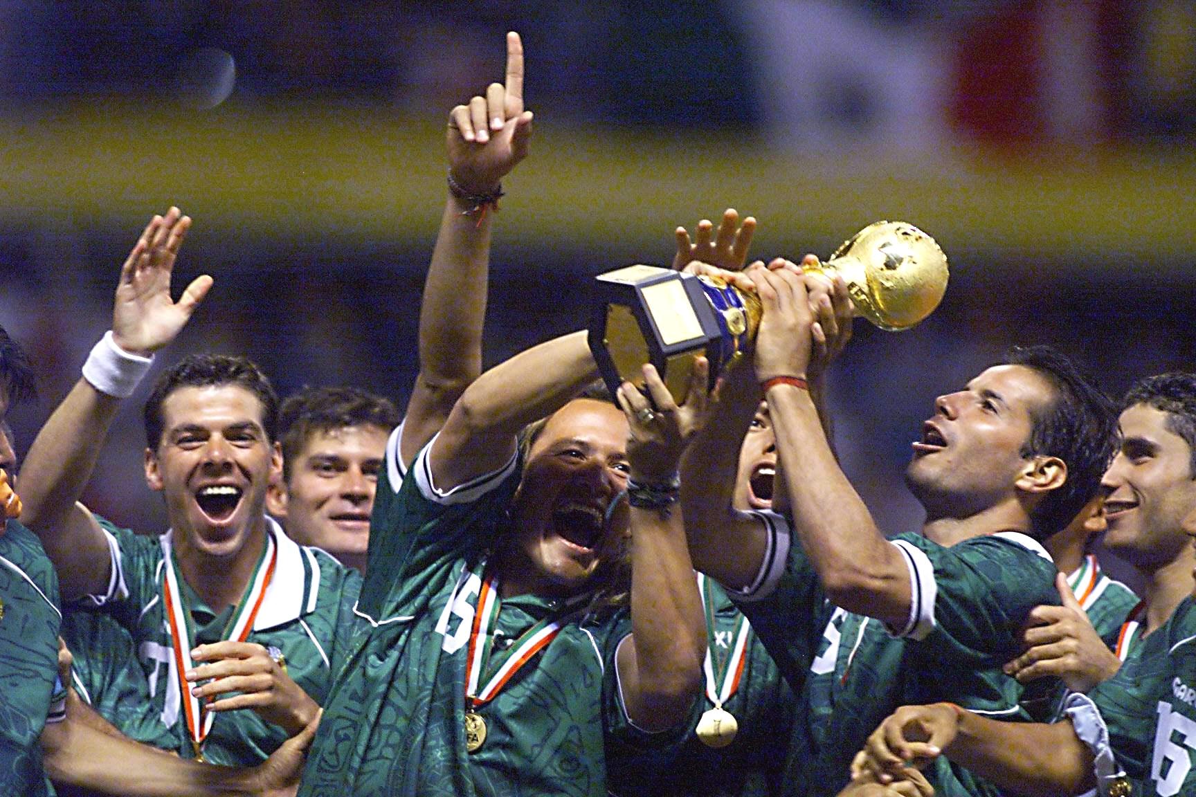 Mexico players celebrate with the Confederations Cup trophy after victory in the final over Brazil in 1999.