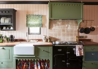 cottage style kitchen with pink victorian tiles paneling and green cabientry craven