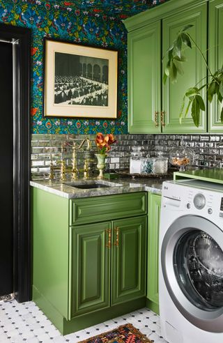 a green laundry room with mirrored tiles