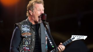 James Hetfield performing onstage in 2012, wearing a battle jacket with various patches