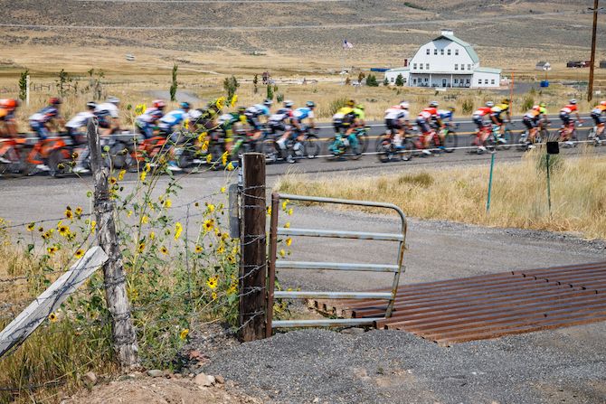 Riders pass by a farm along the route of stage 6 of the 2018 Tour of Utah