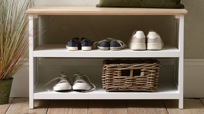 White and wooden shoe bench storage with shoes and basket