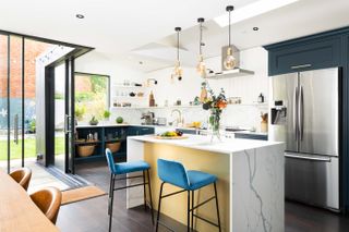 open plan kitchen with marble kitchen island, dark wooden floor, dark blue units, open plan shelving, dining table, view outside