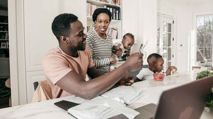 picture of parents with young children working on finances at their kitchen table