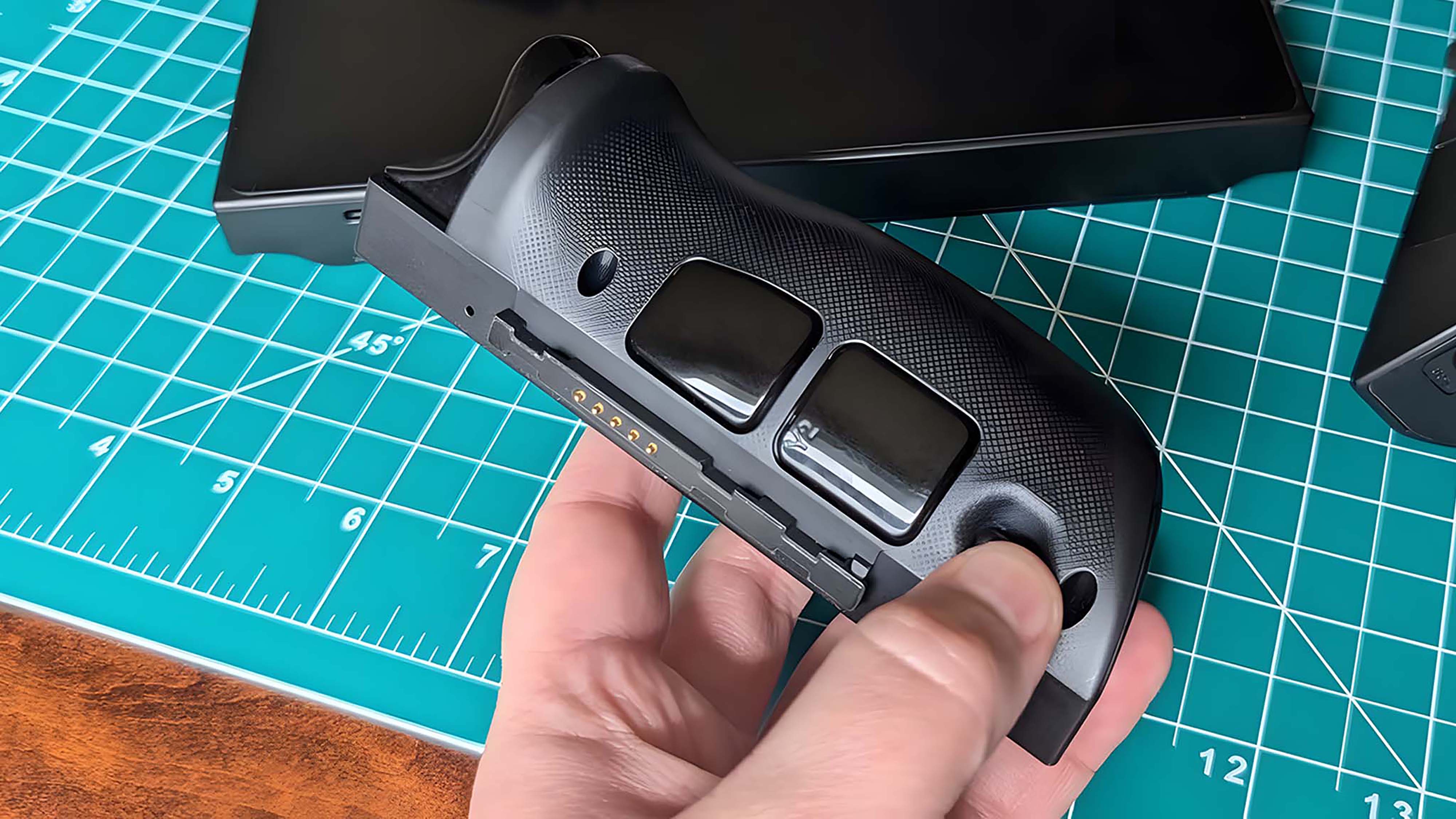 A hand holding the detached right controller of a Lenovo Legion Go.