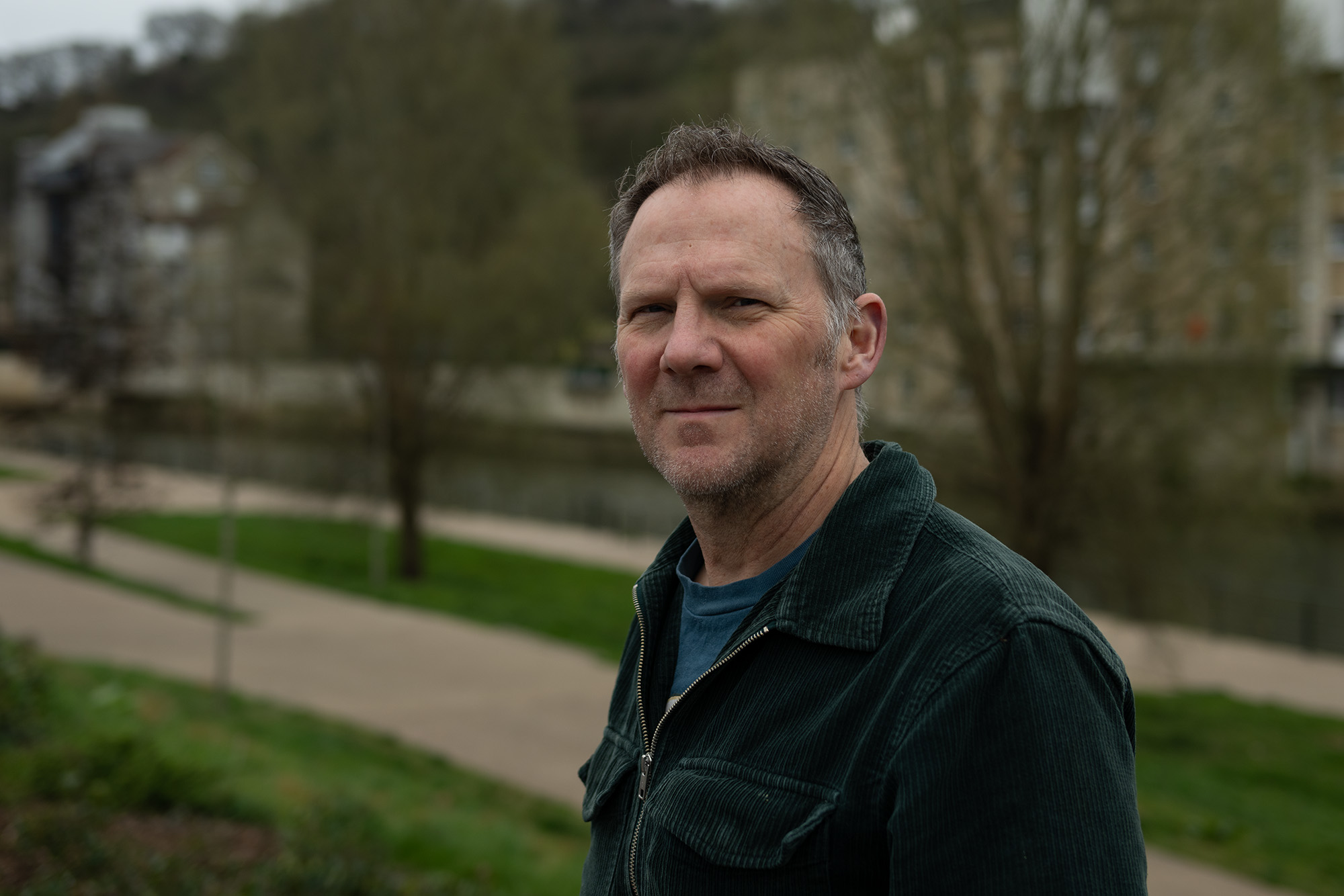 A portrait of Digital Camera World Guides Editor Adam Waring in front of some trees