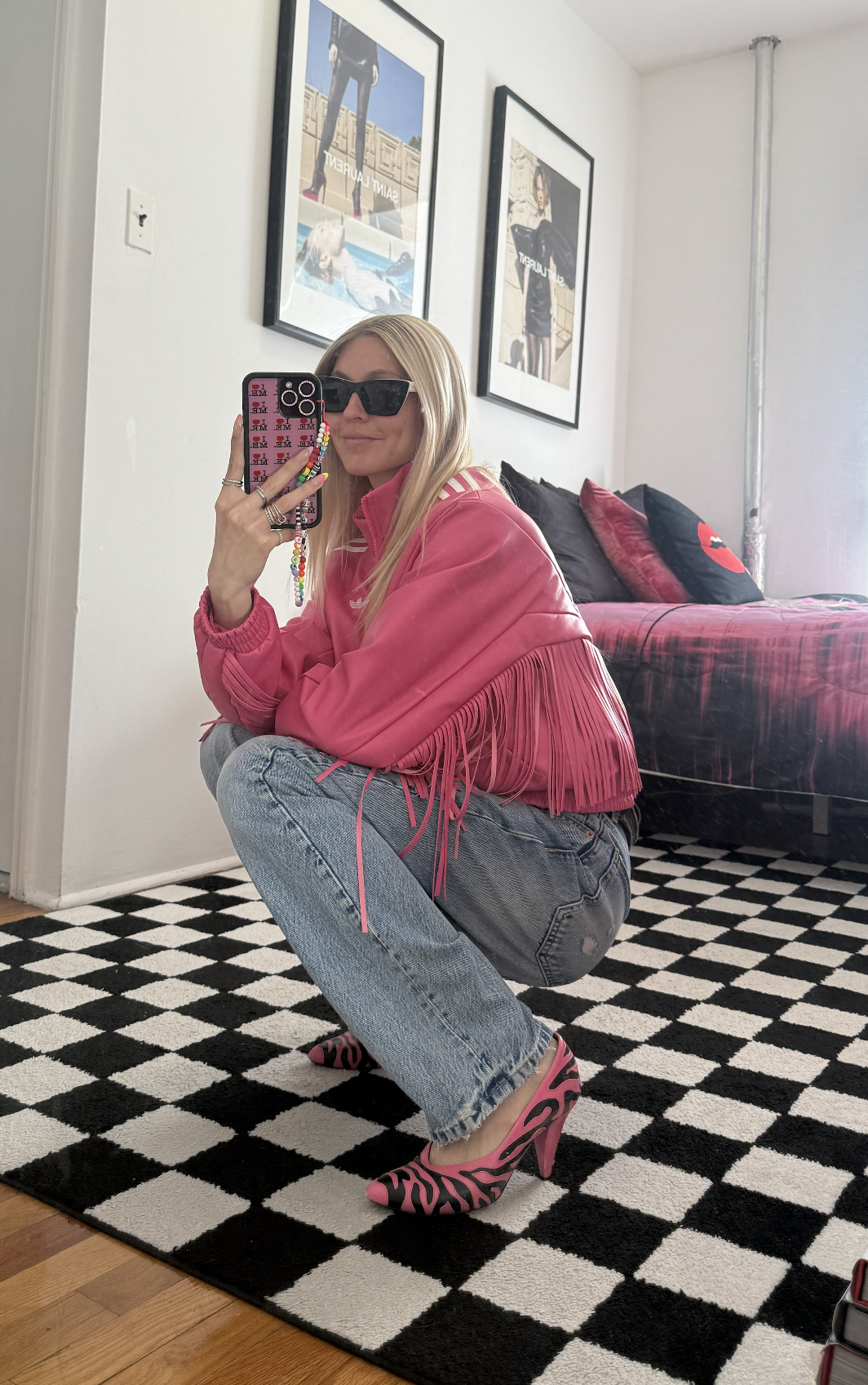 Jessica Minkoff posing in mirror wearing sunglasses, pink jacket 