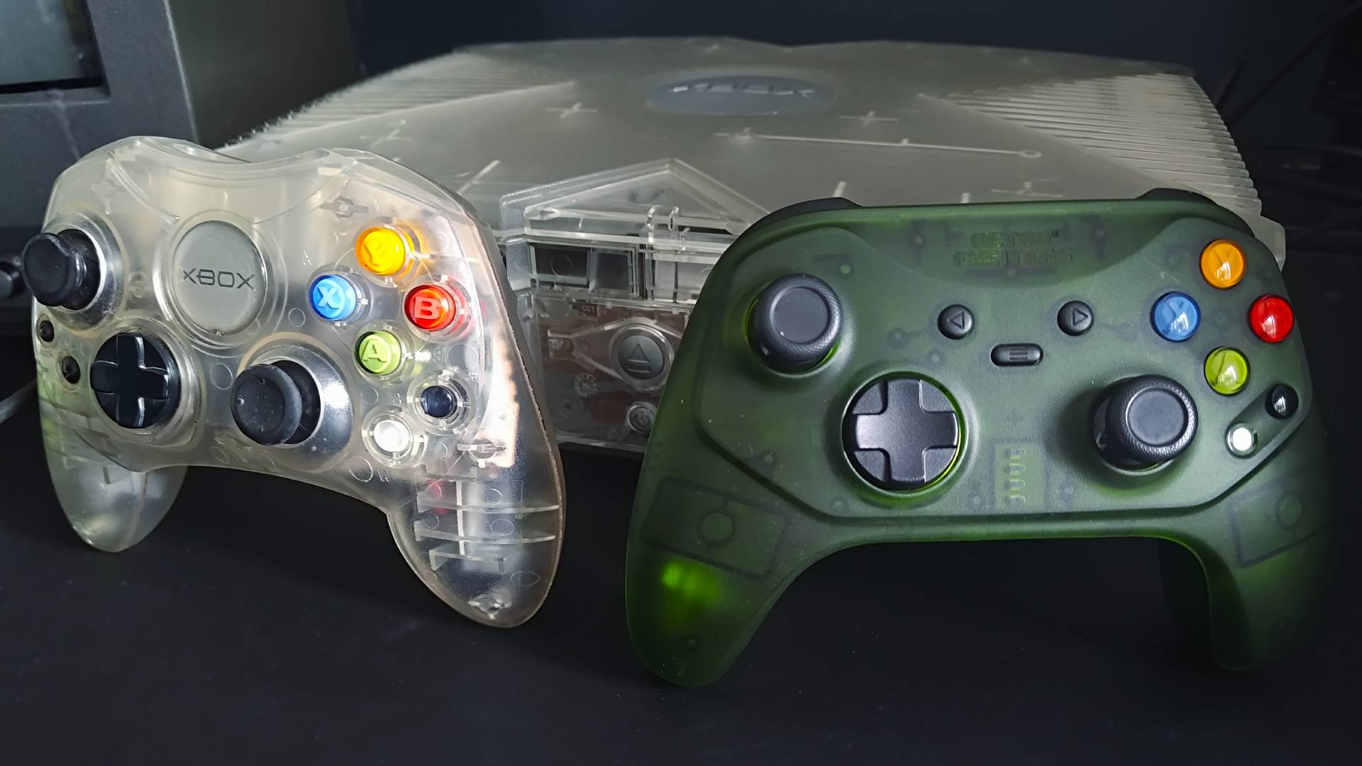 Retro Fighters Hunter on right and OG Xbox S Crystal controller on left leaning against original console.