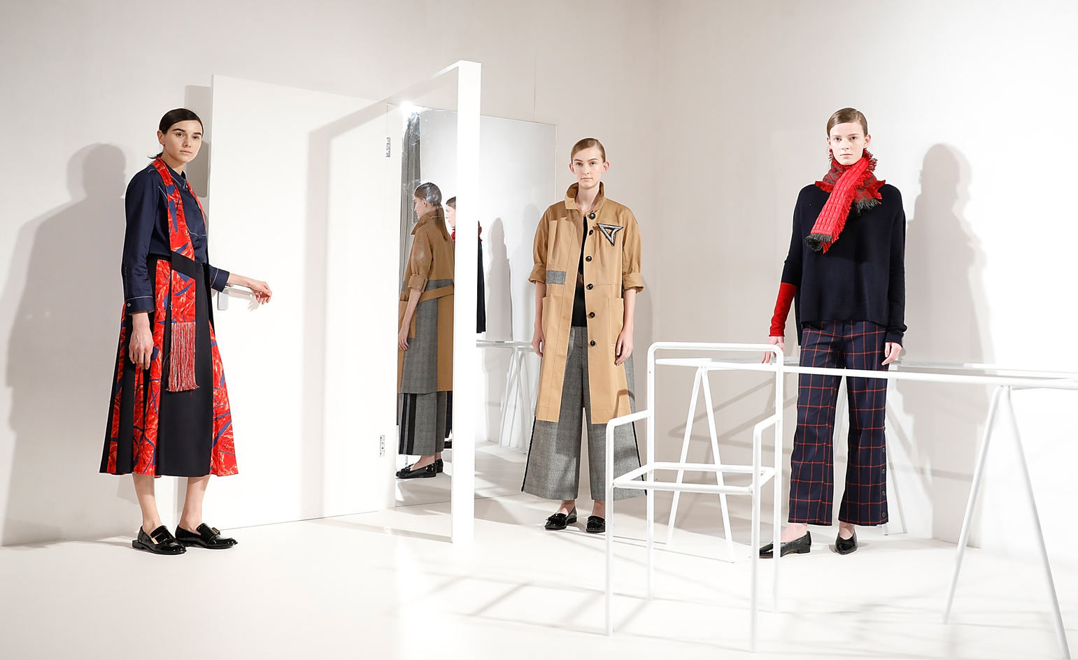 Models wear a range of trenchcoats, checkered wide-leg trousers and statement scarfs