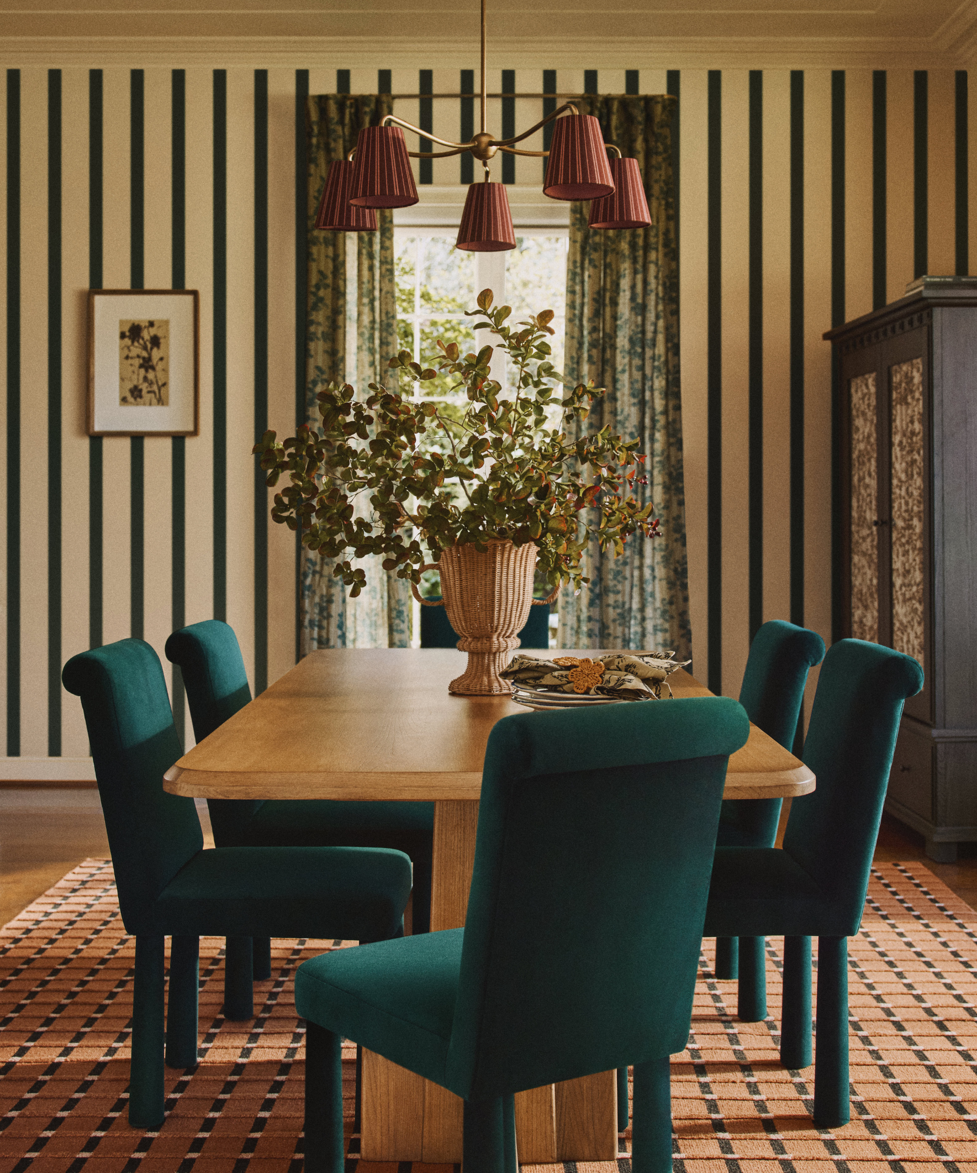 a dining room with green dining chairs, a wooden dining chair, and striped wallpaper