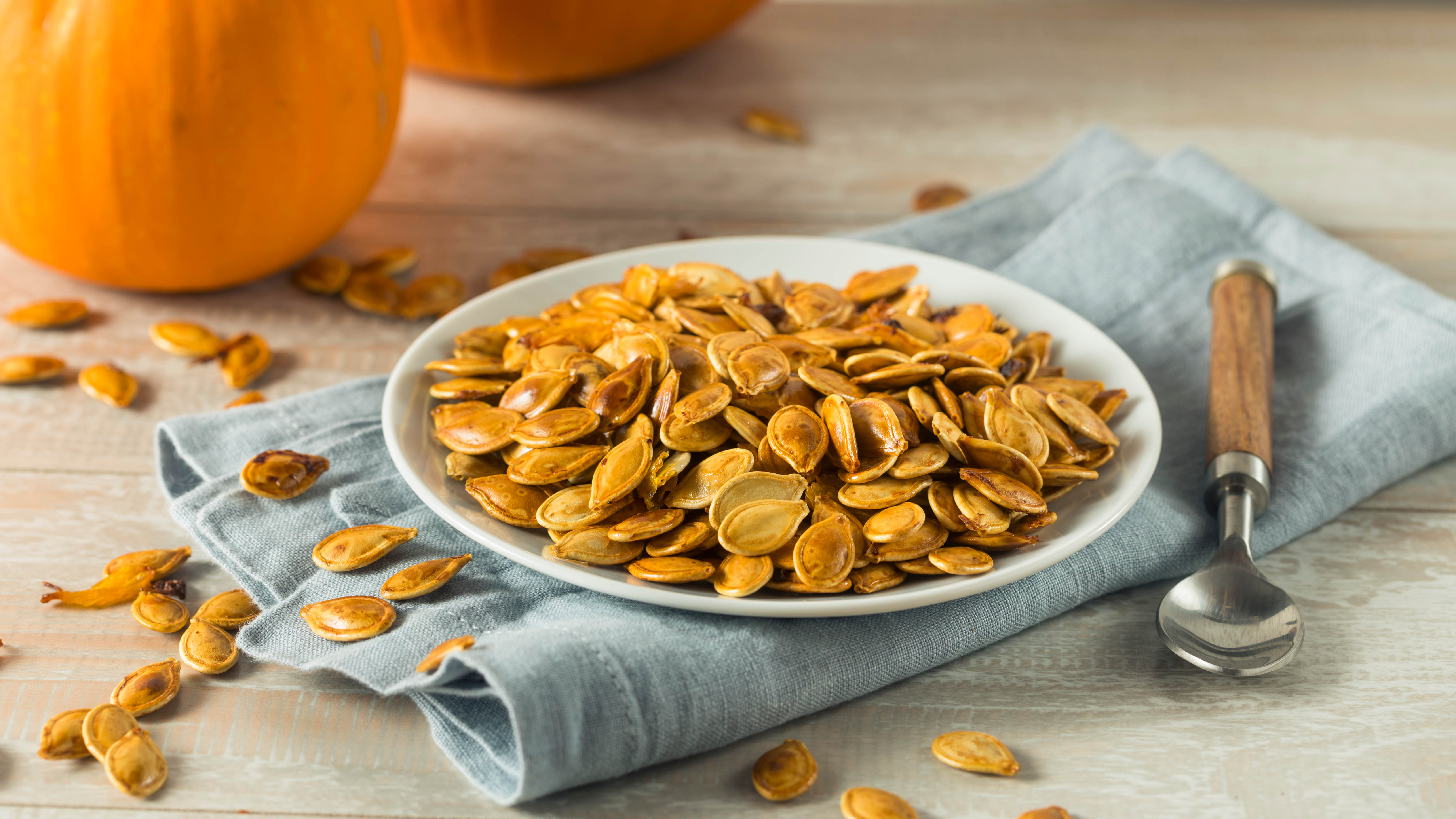 Roasted pumpkin seeds in a bowl on a towel