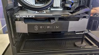 The MSI RTX 4090 24G Suprim Fuzion in a PC, held up by an MSI anti-sag arm, at Computex 2024