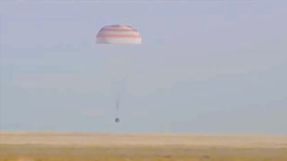 The Soyuz MS-25 lander parachuting down to the surface of the steppe of Khazakstan