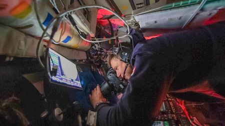 Canadian Space Agency astronaut and Artemis II Mission Specialist Jeremy Hansen is seen taking images through the Orion spacecraft window with Nikon D5