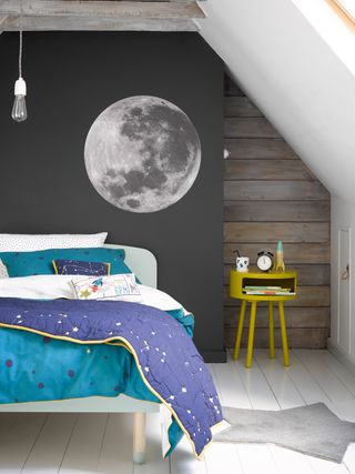 children's bedroom with moon wall mural, child's bed and vibrant bedside table