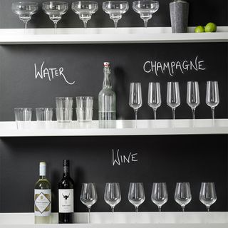 white walled shelf with bottles and glasses