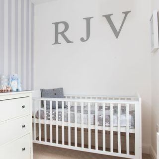 White nursery with monogram above crib