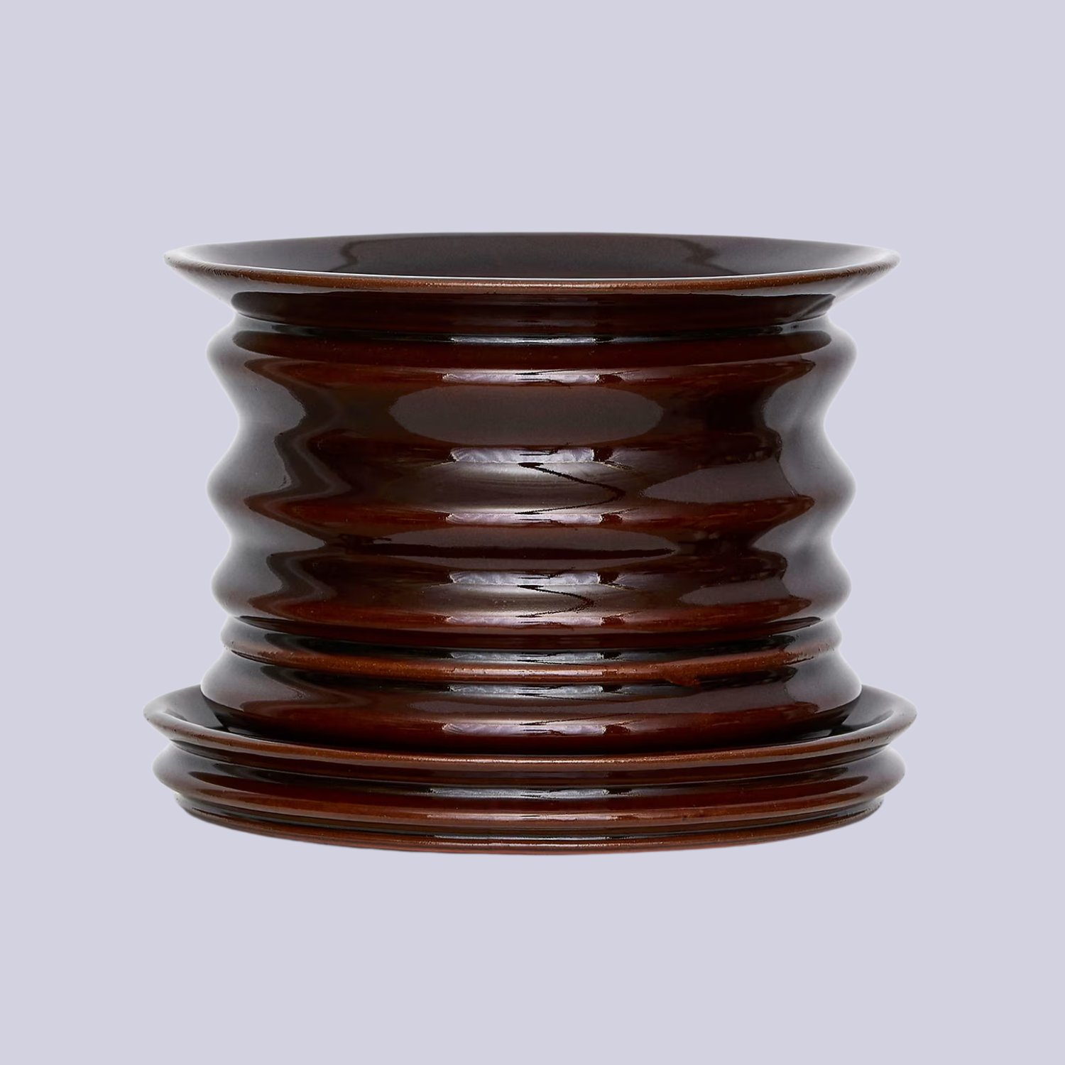 A ridged glazed ceramic plant pot with a saucer