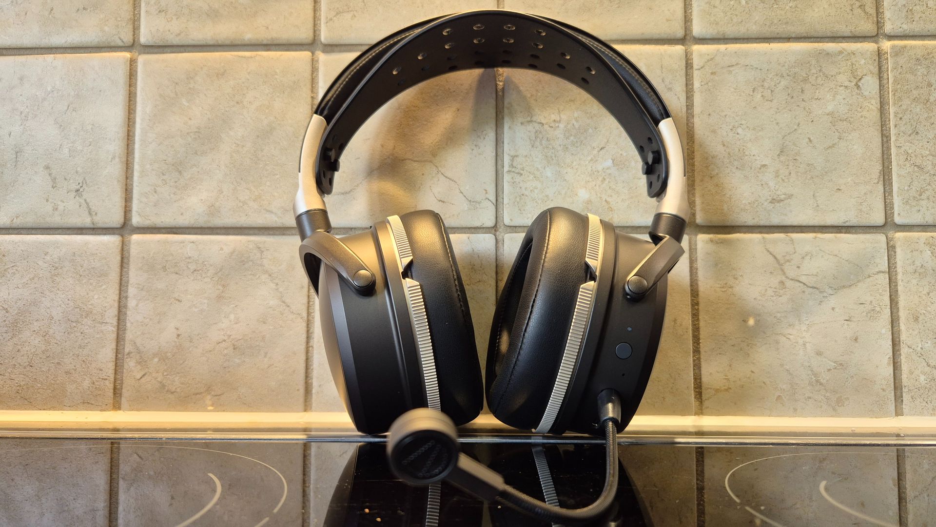A picture of the Audeze Maxwell 2 ANC gaming headset sitting on a shiny surface with pale tiles in the background