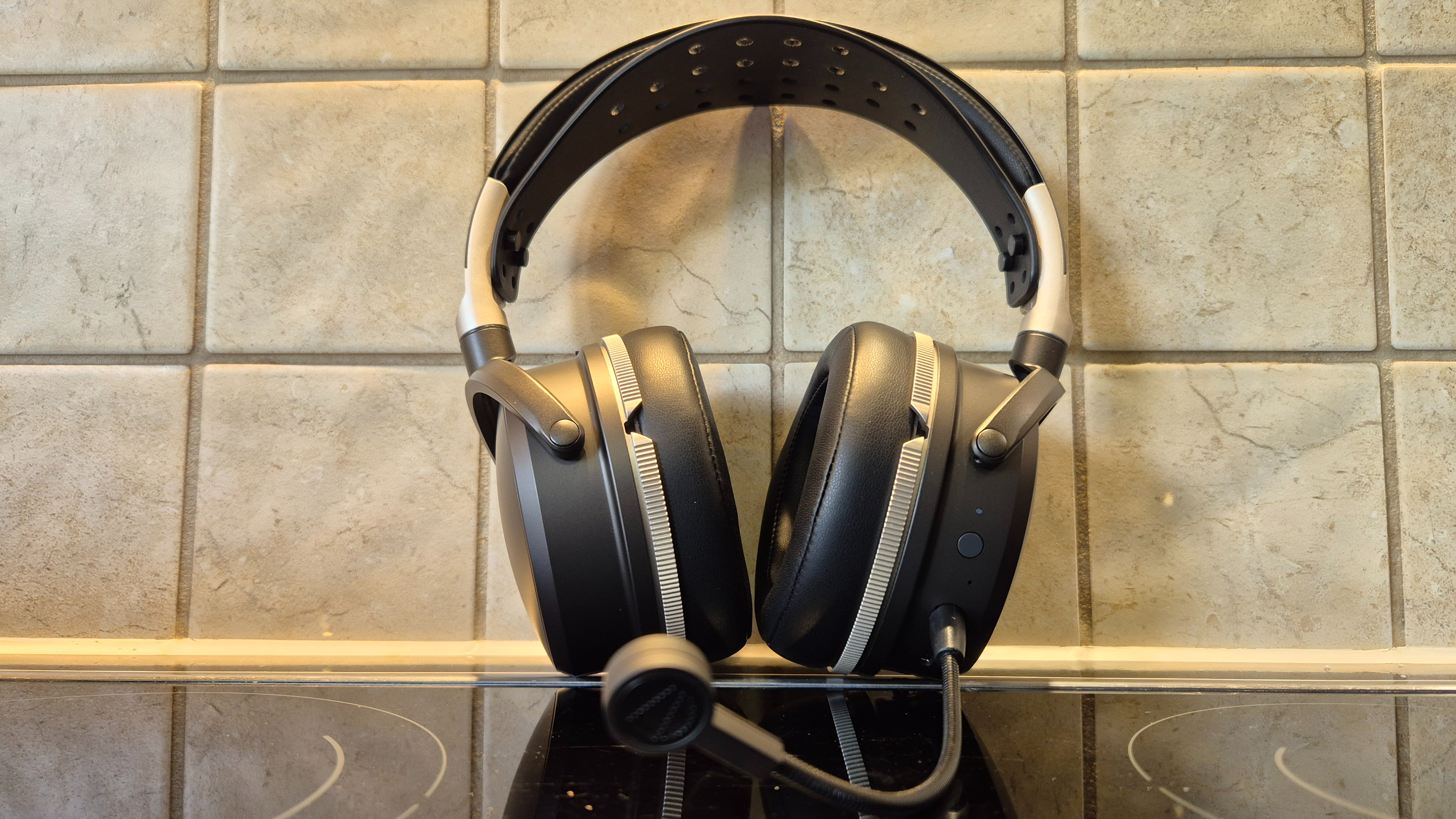 A picture of the Audeze Maxwell 2 ANC gaming headset sitting on a shiny surface with pale tiles in the background