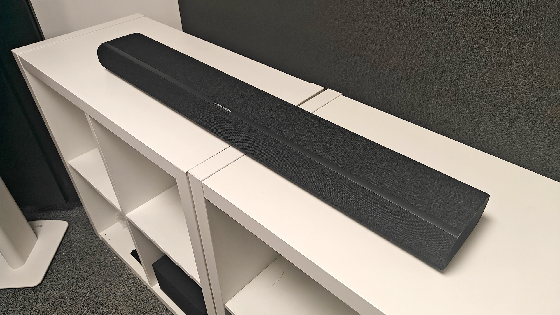 Harman Kardon Enchant 900 soundbar on white wooden shelving unit