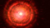 A glowing ball of white light representing a red giant is surrounded by rings of red gas against a black background