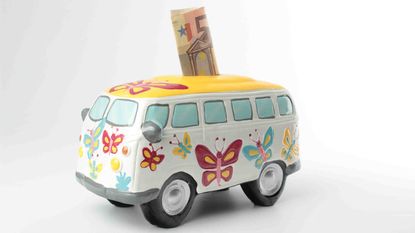 Photo of a ceramic seventies van piggy bank with currency sticking out