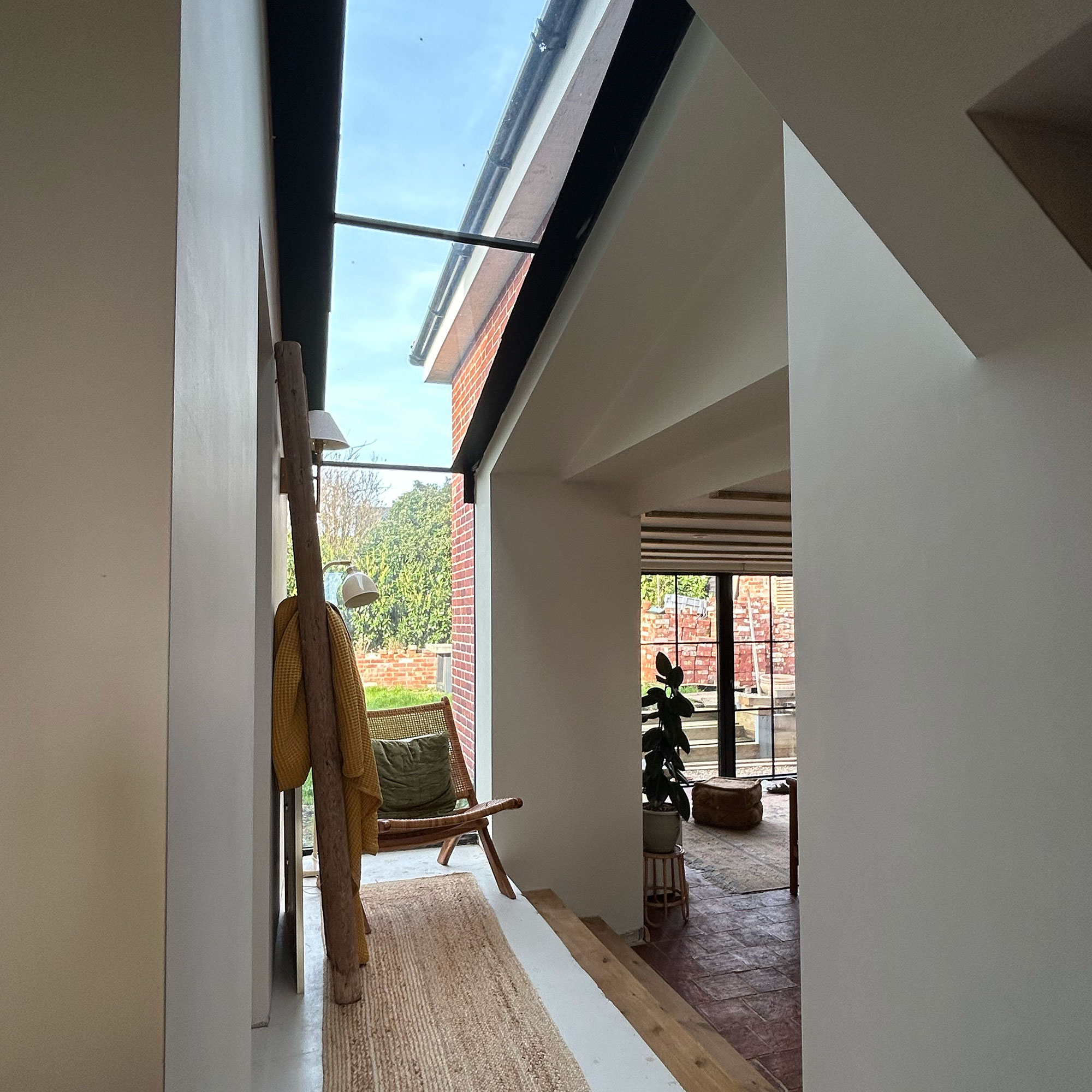 Interior hallway area with jute runner and lounge chair separating rooms