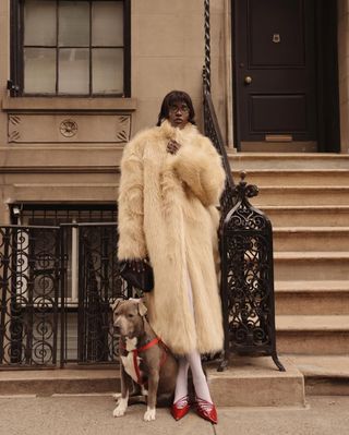 Fashion influencer @lefevrediary and a dog in New York City wearing a chic winter outfit featuring the "wrong tights" micro-trend.