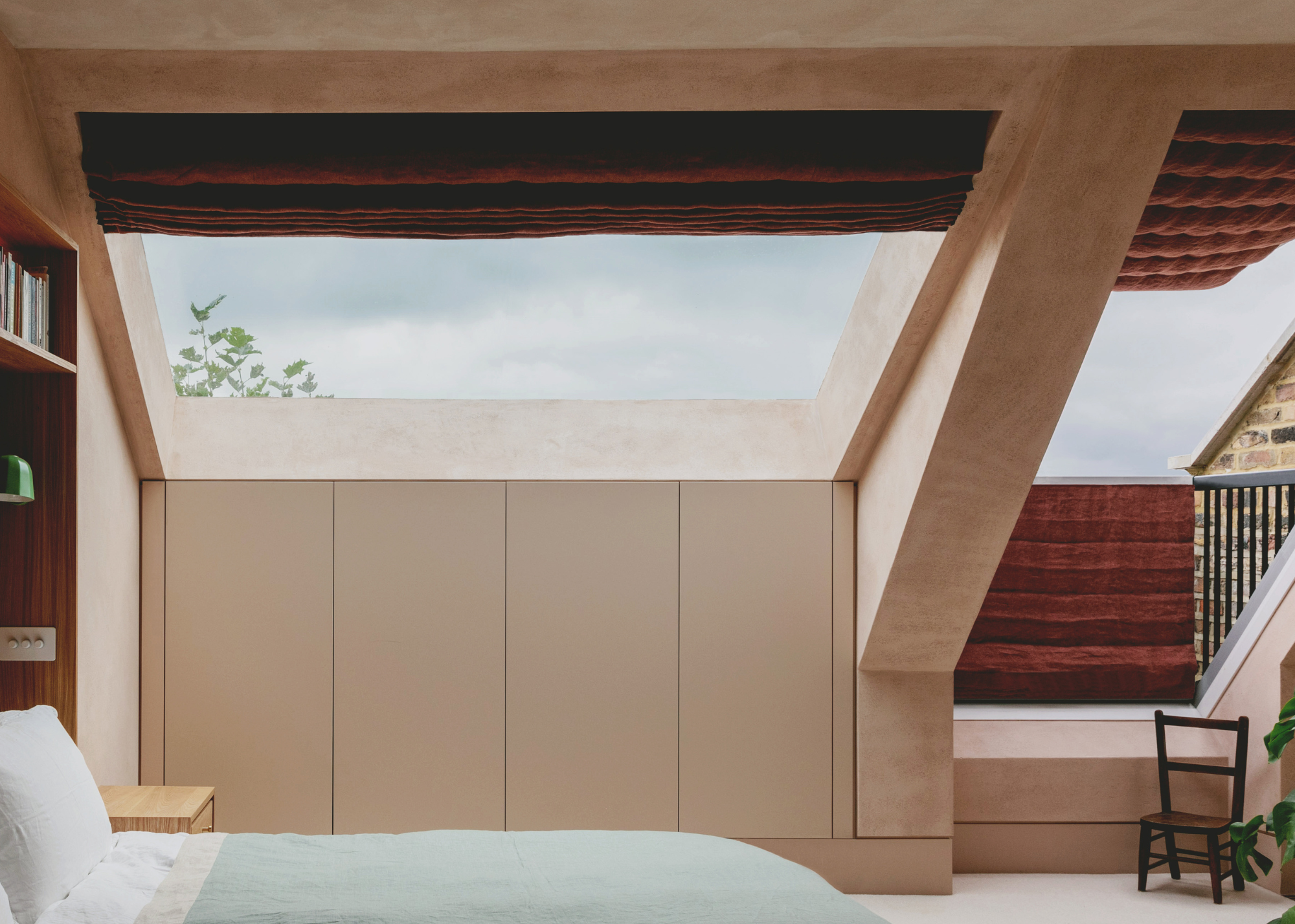 custom wooden bed in a loft bedroom with attached side tables and built in lights and book shelf