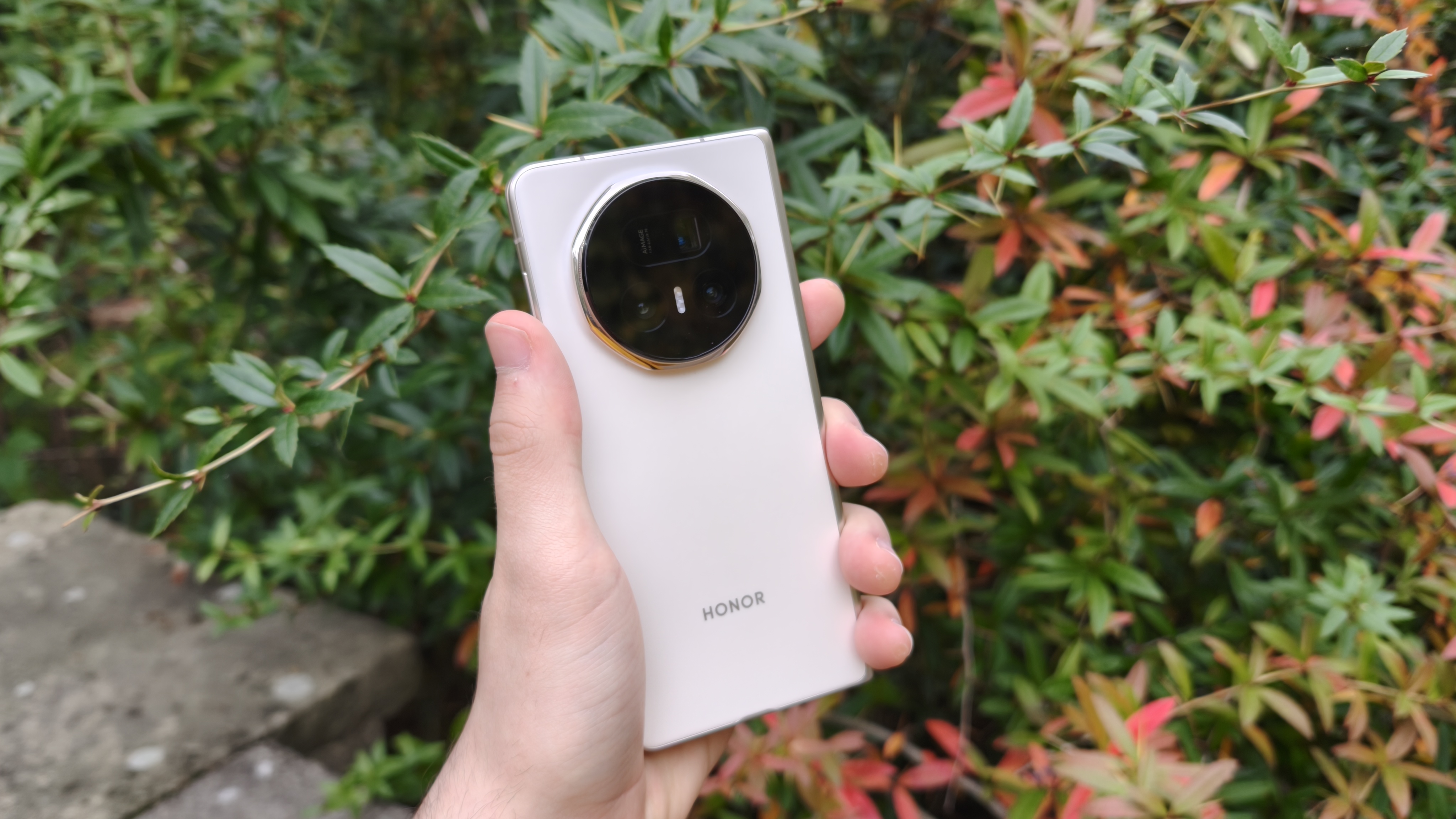 The Honor Magic V5 with some foliage in the background