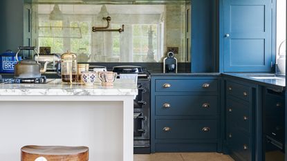dark blue kitchen with white island and coffee cups