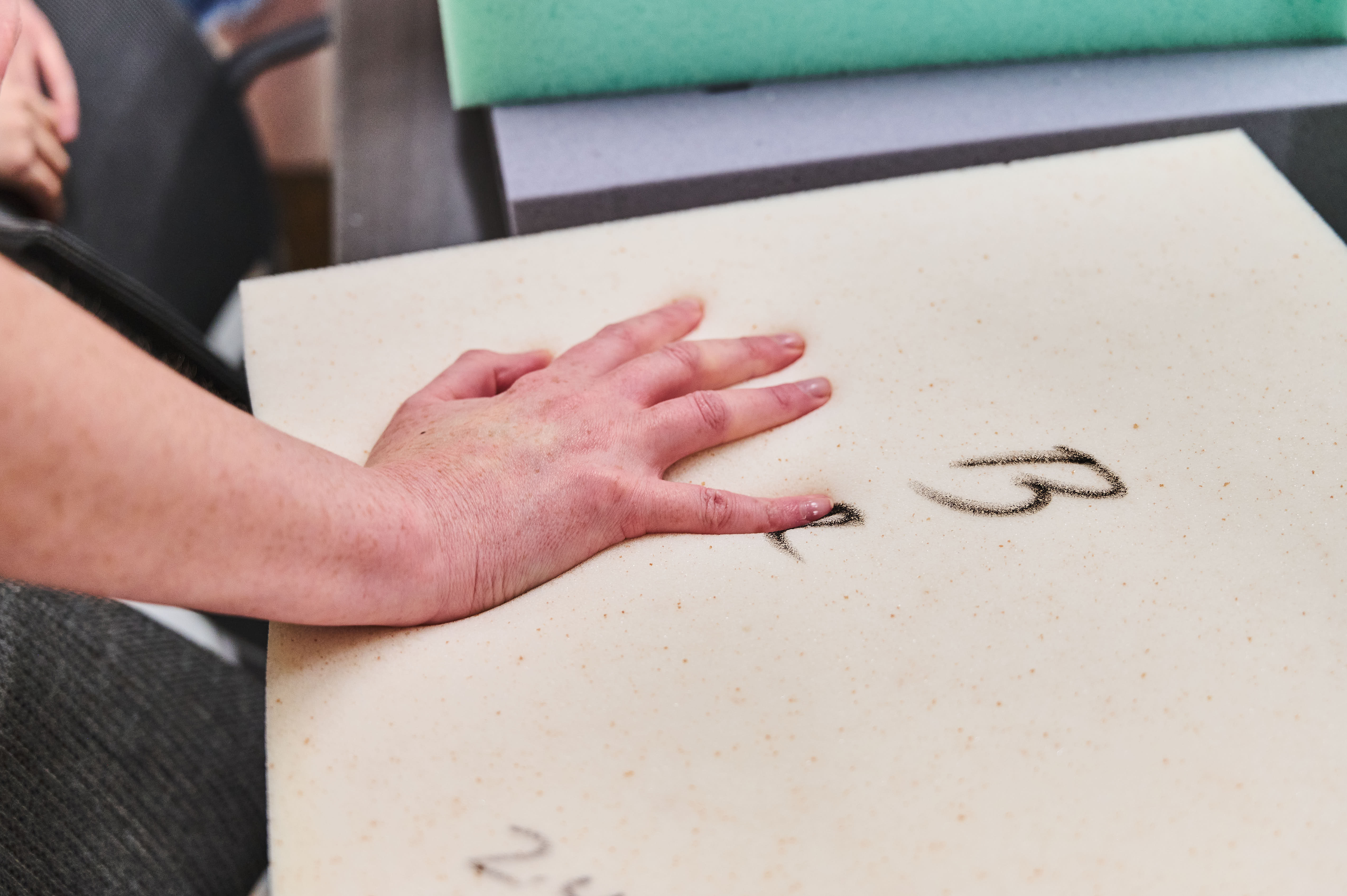 A hand feels memory foam infused with cooling copper gel.