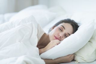 A brunette woman asleep in bed