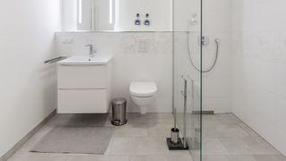 All whte clean bathroom with sink, toilet and shower