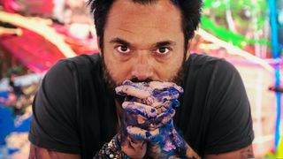 Sacha Jafri interview; a man stares out with paint covered hands