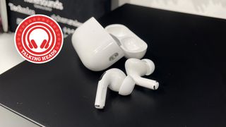 Apple AirPods Pro 2 wireless earbuds out of their case on a black surface