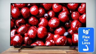 The LG B6 OLED TV displaying a high-contrast, close-up image of dark red-colored cherries. Next to the TV is a superimposed badge that reads: "TG Flex for Less".
