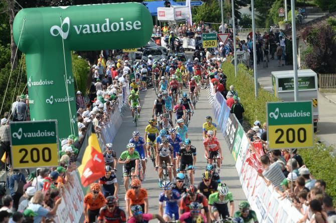 The peloton pick their way past the crash