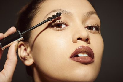 woman sweeping mascara onto her eyelashes