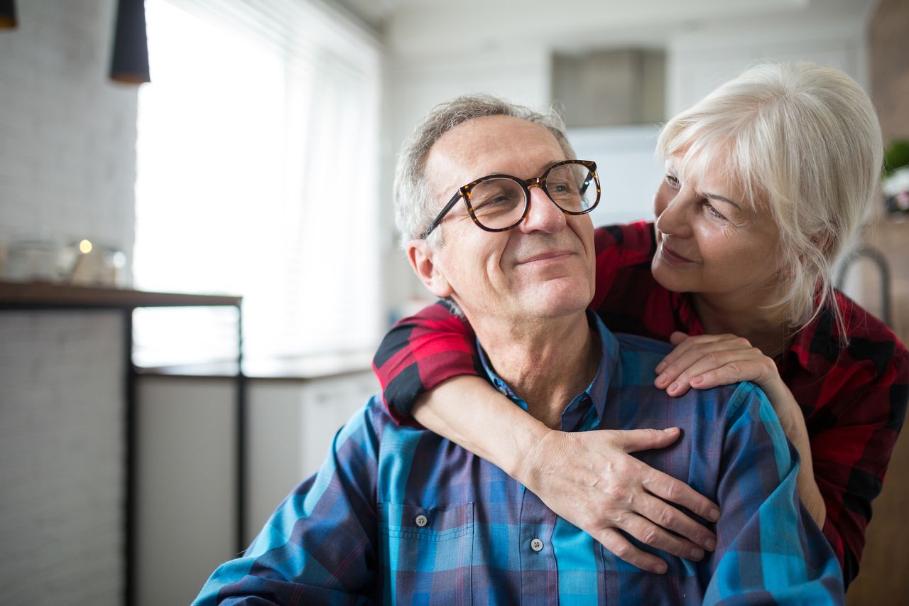 Older couple hug.