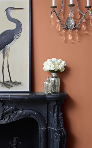 detail of fireplace mantle and orange painted wall